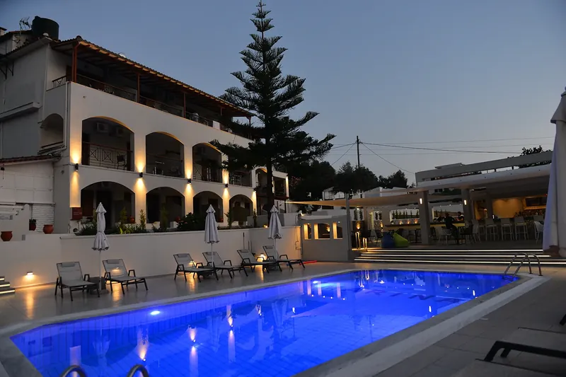 Η πισίνα και το φωτισμένο κτίριο του ξενοδοχείου την μπλε ώρα